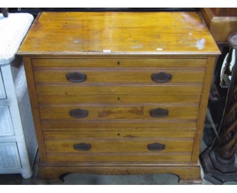 An Edwardian satin walnut bedroom chest of three long drawers with incised tramline detail, raised on bracket supports, toget