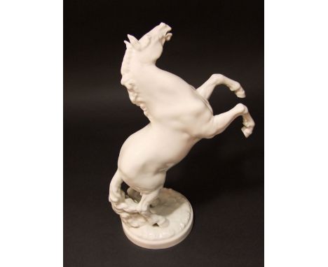 A German white glazed Hutschenreuther model of a rearing horse with printed marks to base and impressed mark K Tutter, 32 cm 