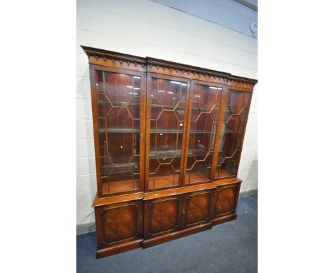 A REPRODUX STYLE MAHOGANY BREAKFRONT FOUR DOOR GLAZED BOOKCASE, enclosing adjustable glass shelves, over four cupboard doors,