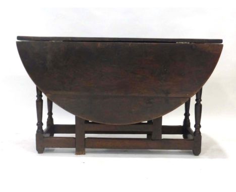 An 18th century elm gate leg dining table with single frieze drawer above turned legs joined by plain stretchers, extends to 