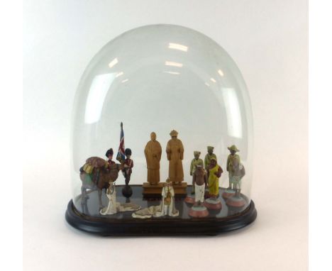 A 19th century glass clock dome, h. 44 cm, containing a group of six Indian plaster figures modelled as soldiers and workers,
