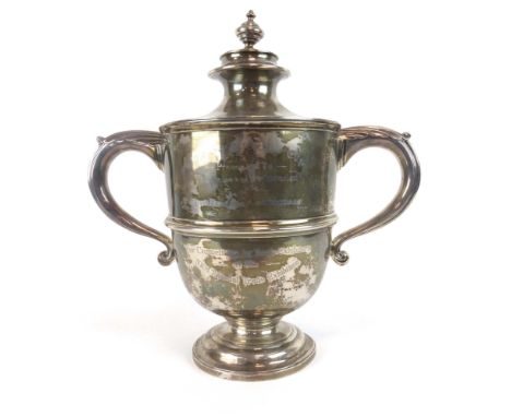 A silver and parcel gilt two handled covered trophy vase having a pair of leaf capped c-scroll handles on a socle base, base 