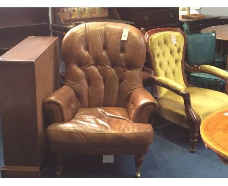 A brown leather button back armchair