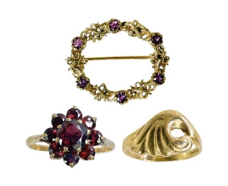 A 9ct garnet set ring, a 9ct ring and a 9ct ruby set brooch. The garnet set cluster ring size R, the wave design ring size M 