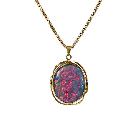 A 9ct mounted black opal triplet pendant on a 9ct box link necklace. The oval opal triplet showing large areas of reds, purpl