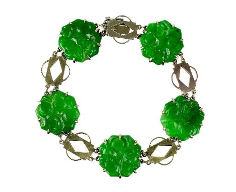 An Art Deco 9ct white gold and green jade panel bracelet. With five carved jade panels between gold openwork panels with chai
