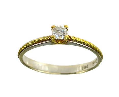 A modern 14ct yellow and white gold 0.10ct diamond solitaire ring. The diamond in a four claw yellow gold twist setting which