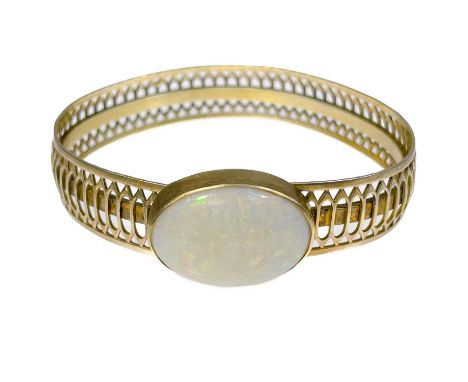 A pierced silver gilt bangle set a large white opal. 24.2g.The front of the stone has some light scratches. The back of the s