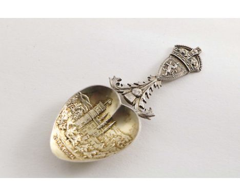 AN EDWARDIAN PARCELGILT CAST CADDY SPOON with the Arms of Scotland, The Royal Crown and a Thistle on the stem and a view of B