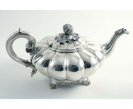 A GEORGE IV MELON-FLUTED TEA POT on decorative scroll feet, with a c-scroll handle and a fruit finial, by Messrs. Barnard, Lo