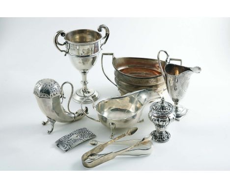 A MIXED LOT:- A horn-shaped sugar caster, a trophy cup, a sauce boat, two pairs of sugar tongs, a card case, a pepper caster,