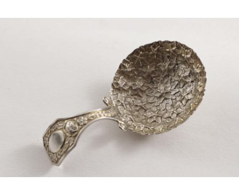 A GEORGE III CADDY SPOON the bifurcated stem with floral decoration and an oval cartouche, the bowl profusely stamped with co