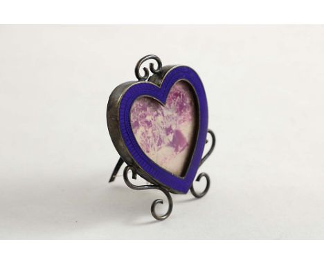 A LATE VICTORIAN MINIATURE HEART-SHAPED PHOTOGRAPH FRAME with an enamelled border, scroll adornment &amp; an easel stand, by 