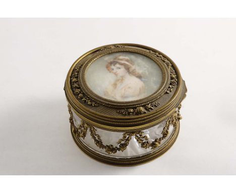 A LATE 19TH / EARLY 20TH CENTURY GILT-METAL MOUNTED GLASS DRESSING TABLE BOX circular with floral festoons around the sides, 