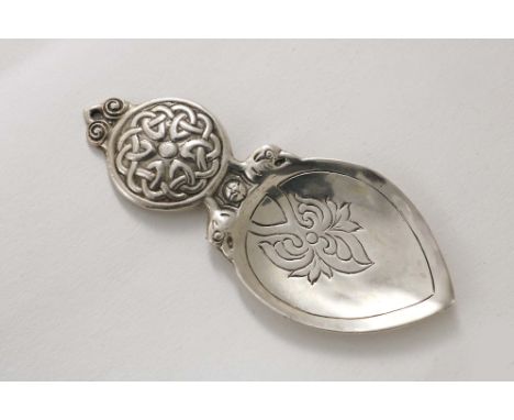 A SCOTTISH CAST CADDY SPOON with a circular lug handle, decorated with "Celtic" knots, and a spade-shaped bowl with a chased 