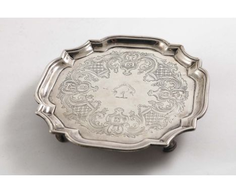 AN EARLY GEORGE II WAITER of shaped square outline with incurved corners, bracket feet and flat-chased border decoration with