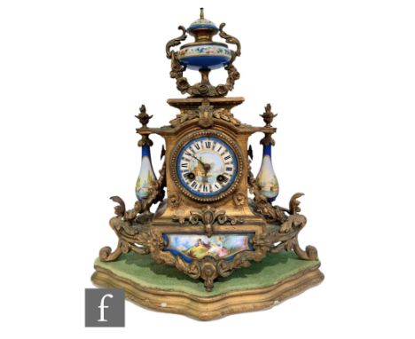 A 19th Century French gilt mantle clock surmounted with an urn over baluster side mounts and Sevres style panels, on a scroll