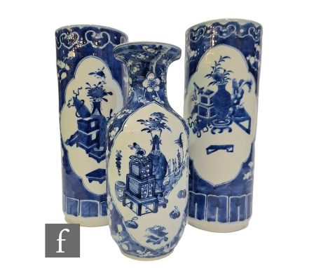 A collection of Chinese late Qing Dynasty blue and white vases, to include a pair of sleeve vases and a single baluster form 