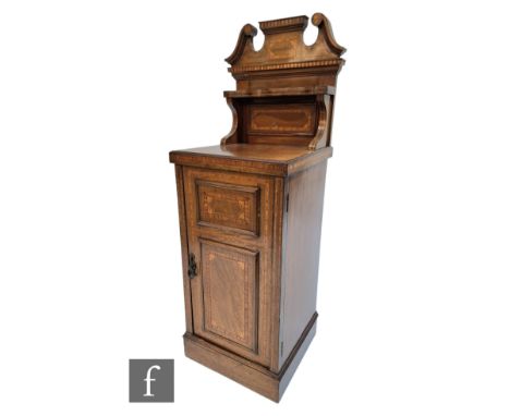 An Edwardian satinwood banded and inlaid bedside cupboard enclosed by a panel door below a broken swan neck ledge, height 118