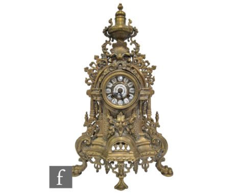 A late 20th Century Louis XIV style gilt mantle clock, surmounted with an urn over a dial, on mask scroll base, height 63cm. 