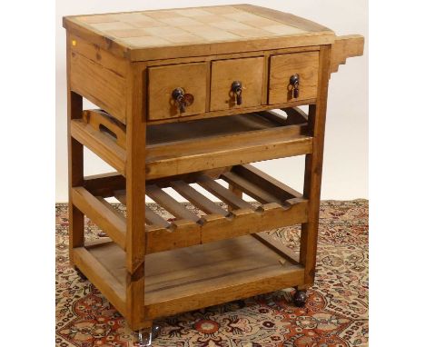 A rustic stained pine and tile-top inset tiered kitchen trolley, having three short upper drawers, w.66cm 