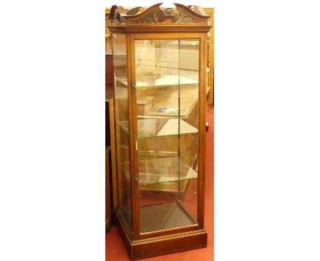 An Edwardian mahogany square section freestanding shop display cabinet, the single door enclosing three interior glass shelve