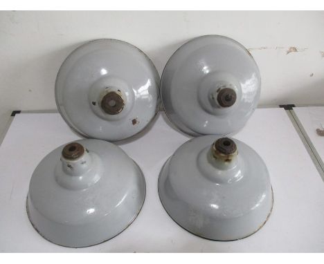 A set of four industrial enamelled light shades