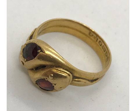 An 18ct gold double head snake ring set with garnets. Total weight 7g