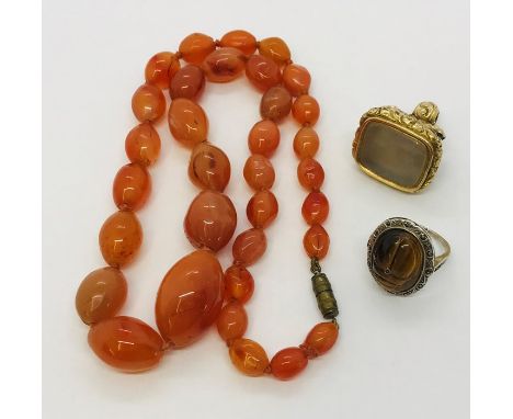 A hard stone necklace, Victorian gilt fob and a silver tigers eye ring.