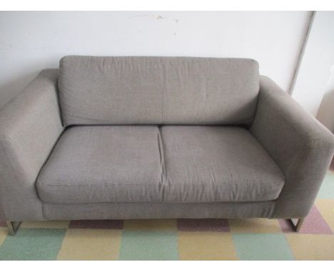 A modern grey sofa with chromed legs