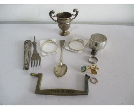 A small silver trophy, serviette ring, thimble along with various other items