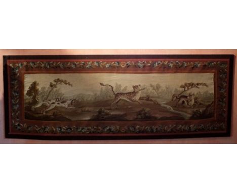 A 17th Century French tapestry panel depicting a pair of hounds to the left chasing a central leopard, rearing, biting the ar