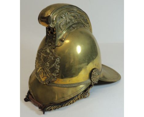 A late 19th/early 20th Century Merryweather brass firemans helmet, the high comb with dragon decoration, applied crossed axe 