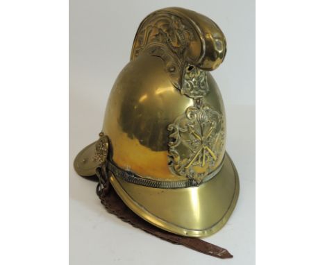 A late 19th/early 20th Century brass Merryweather firemans helmet, the high comb with dragon decoration, crossed axe and hose