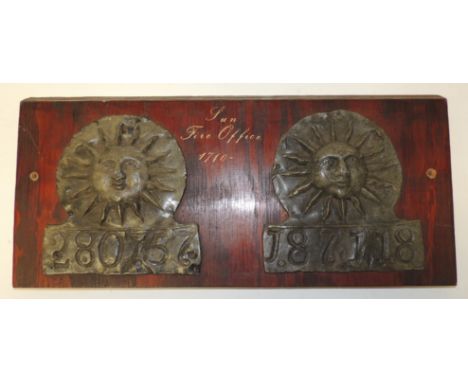 Two early lead fire marks for Sun Insurance Co each with number cast beneath and both mounted on a single wood panel, marks 1