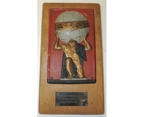 A reproduction of an Atlas fire mark mounted on a wood panel and with plaque beneath, height of mark 27.5cms