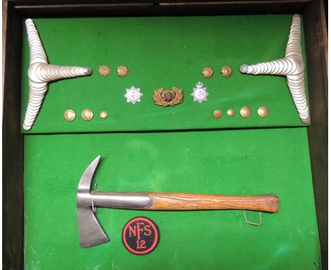 An old display box containing firemans axe, silver metal epaulettes, brass buttons, NFS badges