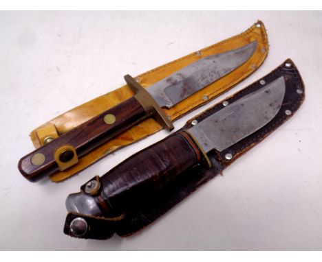 Two hunting knives in leather sheaths 