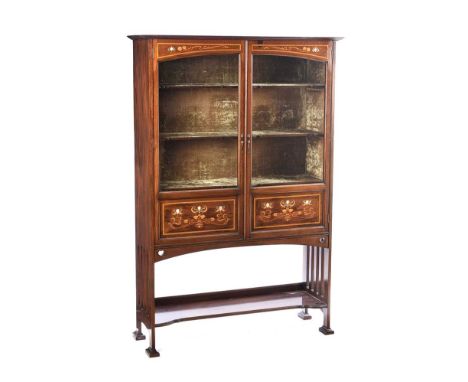 ARTS & CRAFTS TWO DOOR DISPLAY CABINET INLAID WITH SATIN WOOD AND MOTHER OF PEARL. RAISED ON SHAPED FEET.HEIGHT: 67 INCHES.WI