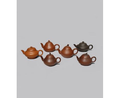 SIX SMALL CHINESE YIXING TEAPOTS AND COVERS QING DYNASTY With ovoid bodies, two plain and four decorated with calligraphy aro