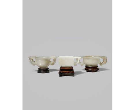 THREE CHINESE PALE CELADON JADE CUPS QING DYNASTY Two with S-shaped bodies and dragon-shaped handles, the third with a square