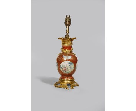 A CHINESE FAMILLE ROSE CORAL-GROUND VASE JIAQING 1796-1820 Decorated with four shaped cartouches with boys in a garden and la