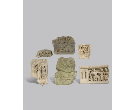 SIX GANDHARAN GREY SCHIST FRAGMENTS C.2ND CENTURY AD One a torso of a seated Buddha, the others scenes of adoration, a feast 