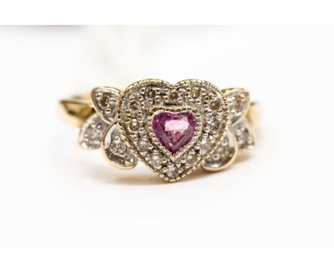 A pink sapphire dress ring, the heart shaped pink sapphire set to the centre with a pave set brilliant cut diamond surround, 