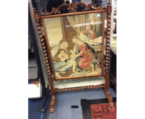 A mid Victorian walnut fire screen, having an inset woolwork panel depicting a religious study, barley twist columns, carved 