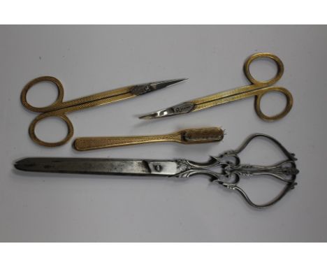 Two pairs of Asprey gilded dressing table scissors with engine turned decoration, together with a matching brush, and a pair 