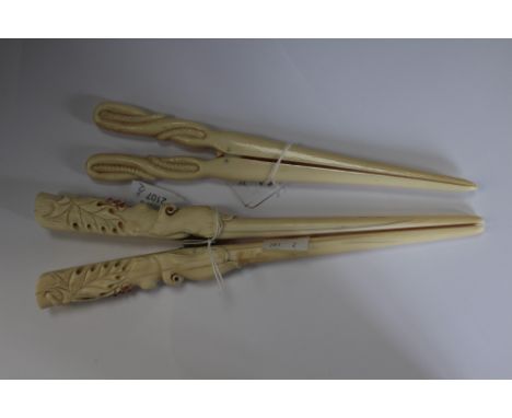  Two pairs of 19th century ivory glove stretchers, one with twisted rope decoration and the other with leaves and berries mad