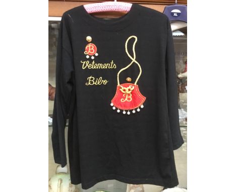 A mid to late 1970's black long sleeved top, embellished with a red satin handbag with a gold rope, handle with a knotted c h