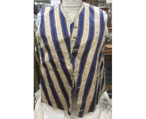 A Victorian gentleman's silk waistcoat from 1840/55 in cream and deep blue striped silk,with flower design,pearl buttons,roun