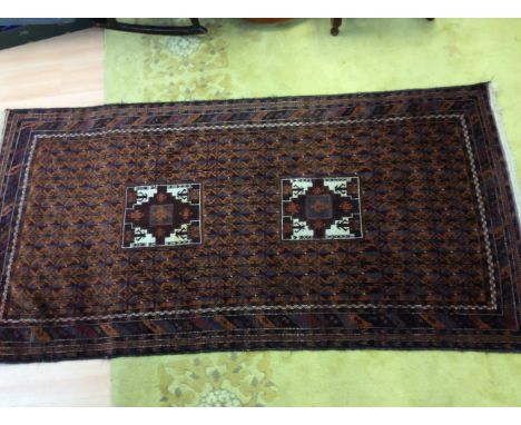 A 20th Century carpet, geometric design in rust coloured hues, 110cm by 220cm